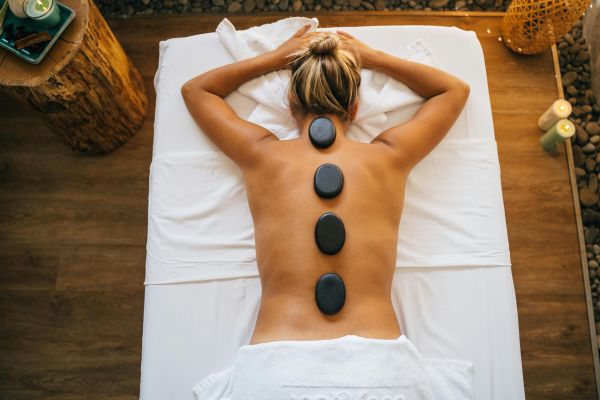 A woman enjoying a rejuvenating hot stone massage in a tranquil spa setting.